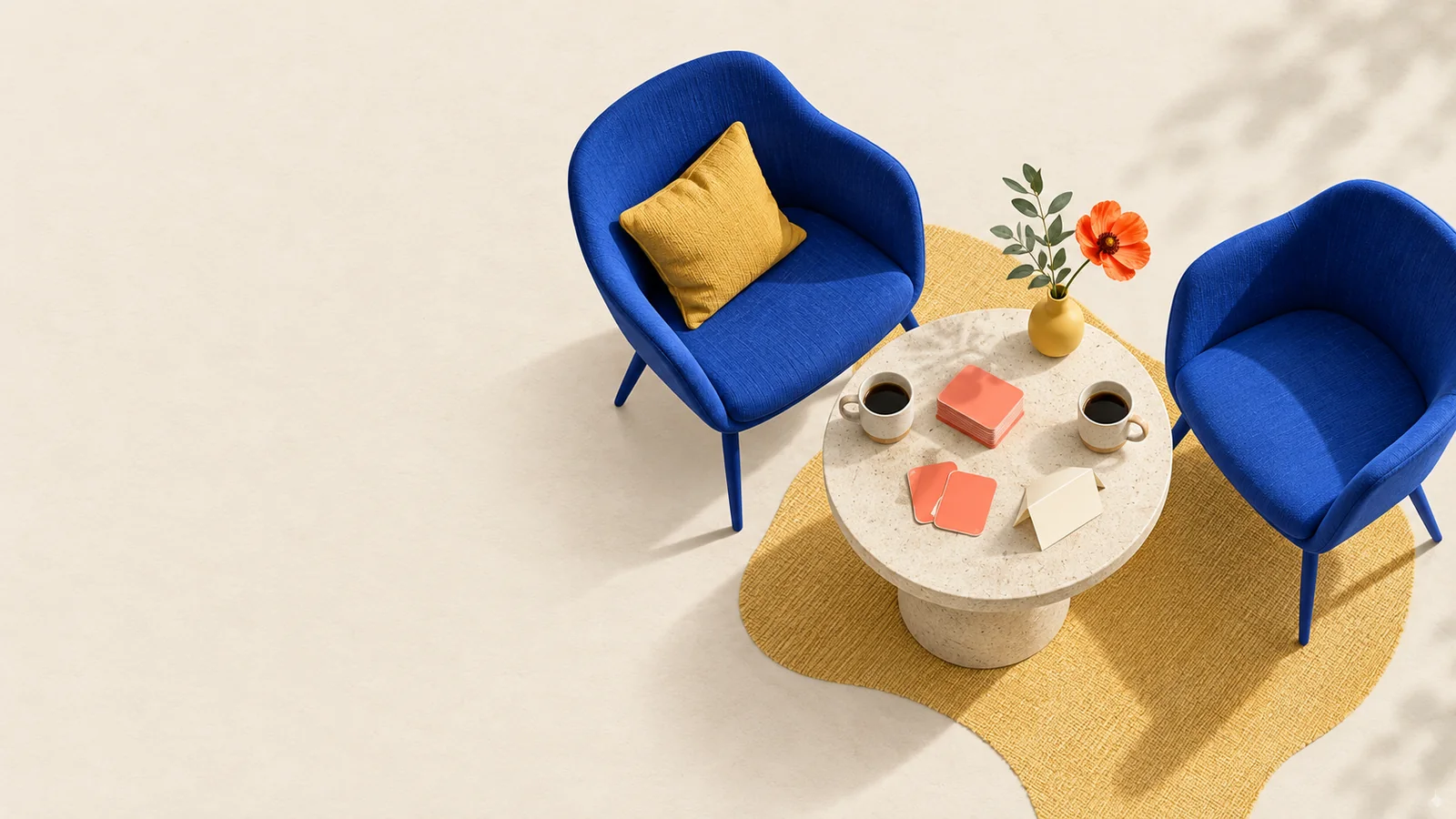 Two blue chairs beside a table with coffee and question cards